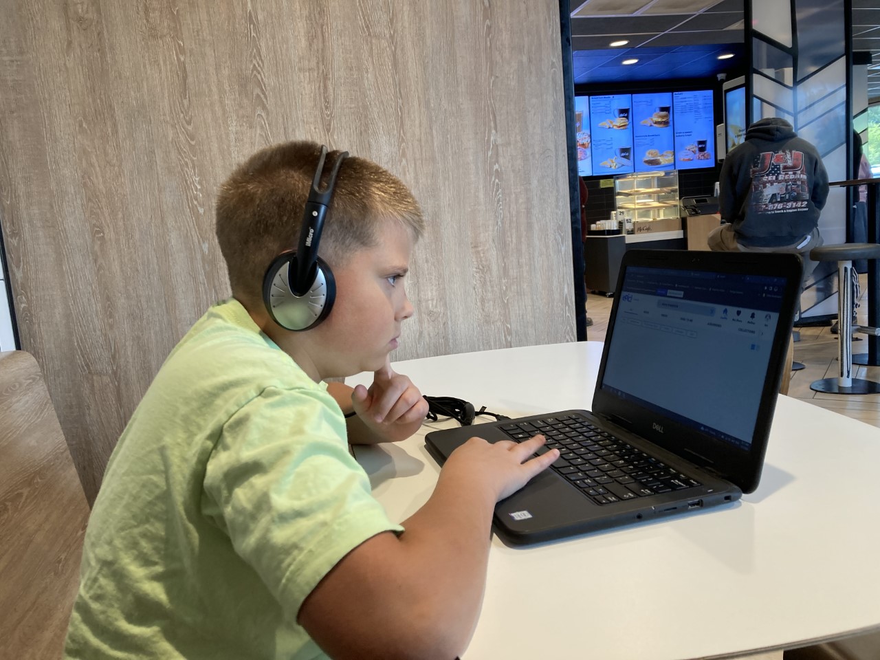 Image of a child learning online in a virtual class on a laptop computer with headphones.