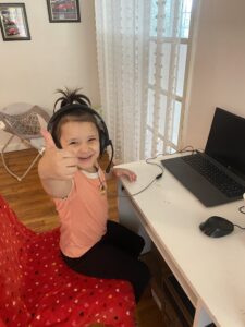 An Insight PA student giving a thumbs up to the camera while learning from home.